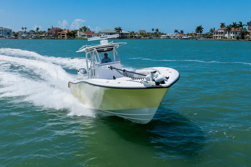 Slide: The Image of 2007 Yellowfin 34 Offshore boat cruising on clear blue water near coastal homes. - 11