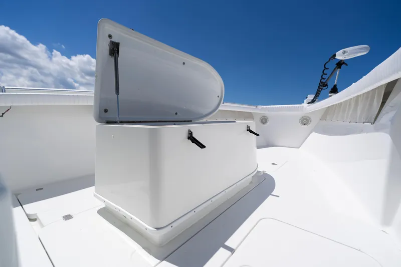 Slide: The Image of 2007 Yellowfin 34 Offshore boat deck with open storage compartment under clear blue sky. - 26