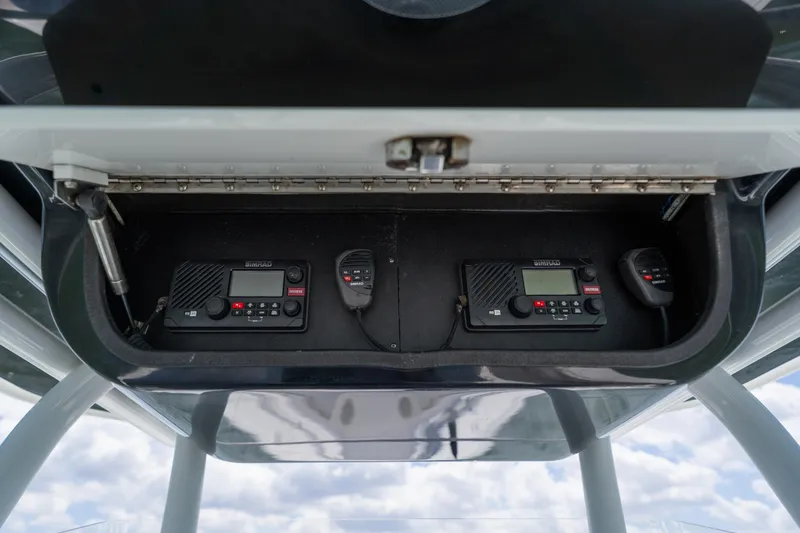 Slide: The Image of 2007 Yellowfin 34 Offshore boat radio equipment in storage compartment, featuring dual Simrad units. - 36