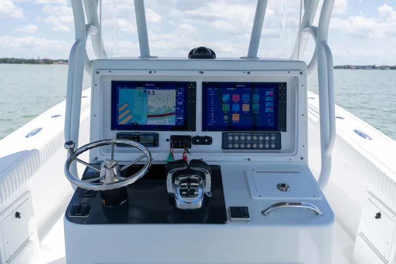 Slide: The Image of 2007 Yellowfin 34 Offshore boat dashboard with dual navigation screens and steering wheel. - 37