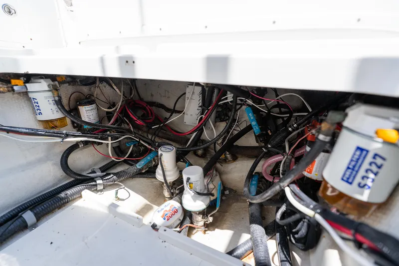 Slide: The Image of Engine compartment of a 2007 Yellowfin 34 Offshore boat, showing wiring and filters. - 62