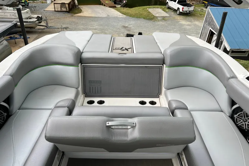 Slide: The Image of 2017 MasterCraft XT23 boat interior with gray seating and cup holders. - 10