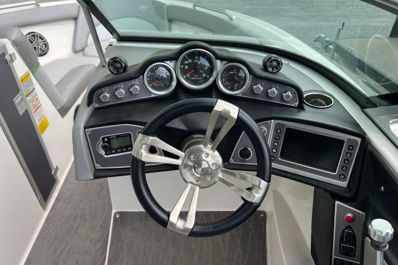 Slide: The Image of 2017 MasterCraft XT23 boat dashboard with steering wheel, gauges, and control panel. - 4