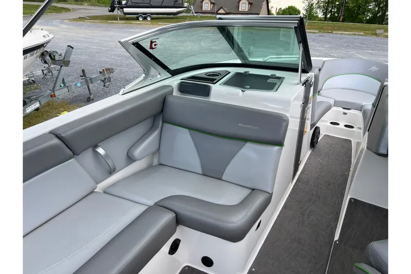 Slide: The Image of 2017 MasterCraft XT23 boat interior with gray seating and green accents. - 5