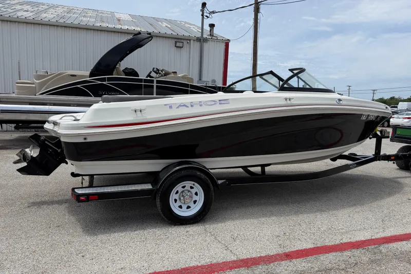 Slide: The Image of 2016 Tahoe 500 TF boat on trailer, parked outdoors near other boats. - 15