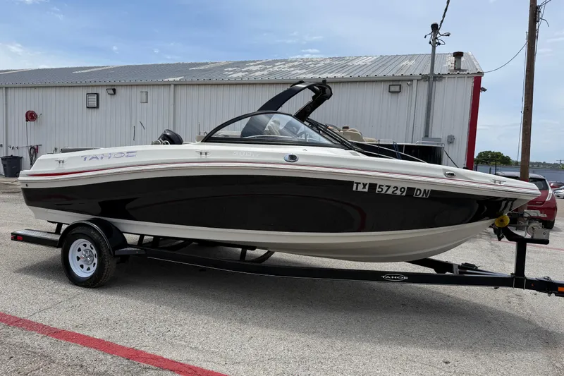 Slide: The Image of 2016 Tahoe 500 TF boat on trailer, parked near a metal building. - 16