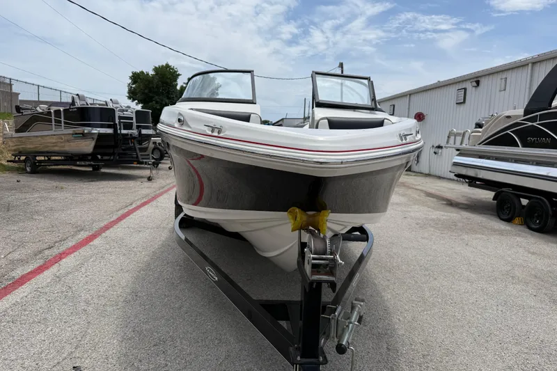 Slide: The Image of 2016 Tahoe 500 TF boat on trailer, parked outdoors under a partly cloudy sky. - 17
