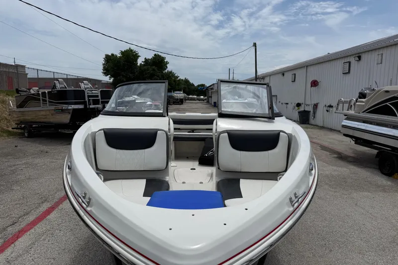 Slide: The Image of 2016 Tahoe 500 TF boat with open bow seating, parked outdoors near other boats. - 18