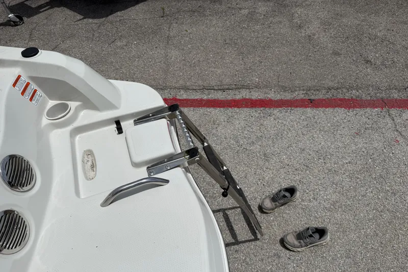 Slide: The Image of 2016 Tahoe 500 TF boat with ladder and shoes on pavement. - 24