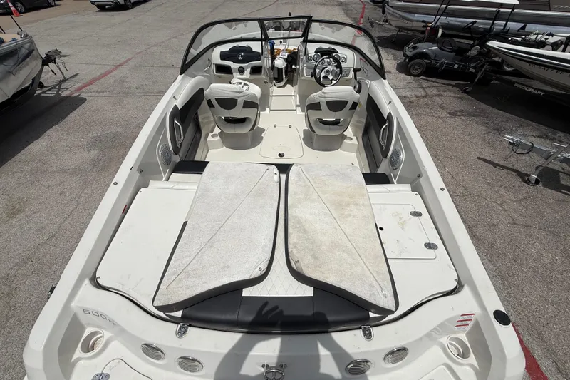 Slide: The Image of 2016 Tahoe 500 TF boat interior with seating and steering wheel, parked on pavement. - 25