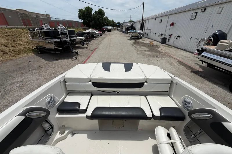 Slide: The Image of 2016 Tahoe 500 TF boat interior with white and black seating, parked in a storage area. - 31