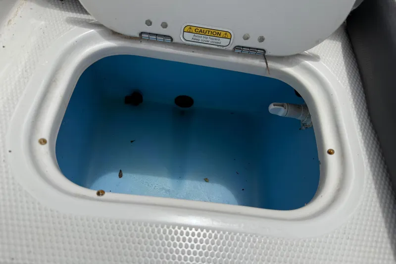 Slide: The Image of Open storage compartment in a 2016 Tahoe 500 TF boat, featuring a blue interior. - 56