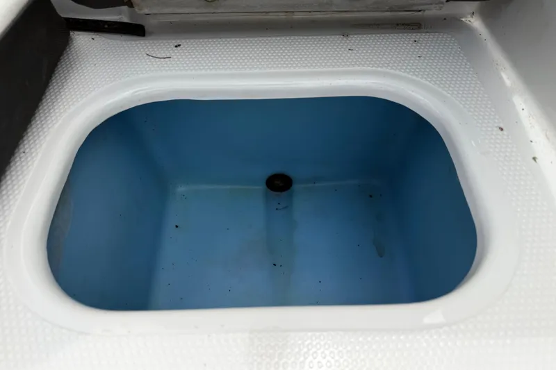 Slide: The Image of Open storage compartment in 2016 Tahoe 500 TF boat, featuring a blue interior. - 58
