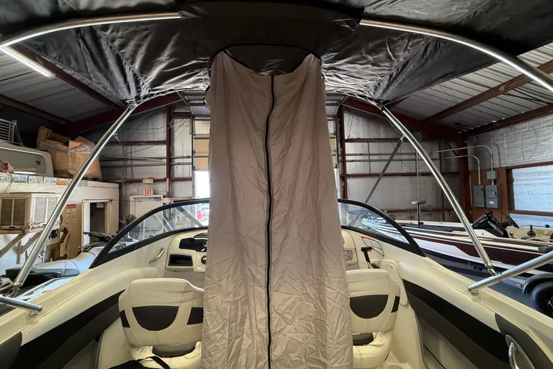 Slide: The Image of 2016 Tahoe 500 TF boat interior with canopy in a storage facility. - 62