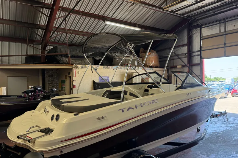 Slide: The Image of 2016 Tahoe 500 TF boat in a warehouse, featuring sleek design and canopy. - 66