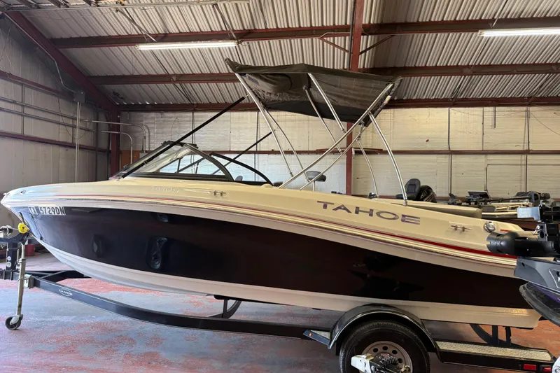 Slide: The Image of 2016 Tahoe 500 TF boat in a warehouse, featuring a sleek design and canopy. - 68