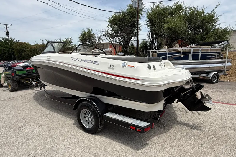Slide: The Image of 2016 Tahoe 500 TF boat on trailer, parked outdoors, showcasing sleek design and black-white color scheme. - 8