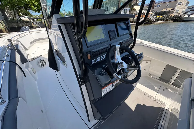 Slide: The Image of 2020 Blackfin 272 CC boat cockpit with steering wheel and navigation display. - 12