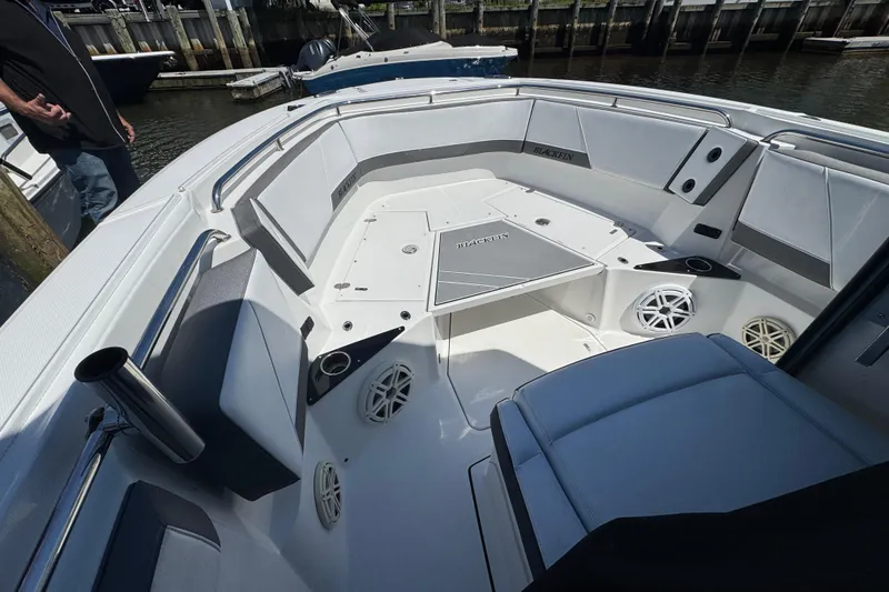 Slide: The Image of 2020 Blackfin 272 CC boat interior with seating and speakers at a dock. - 15