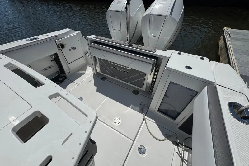 Slide: The Image of 2020 Blackfin 272 CC boat deck with dual Mercury engines, docked by the water. - 26