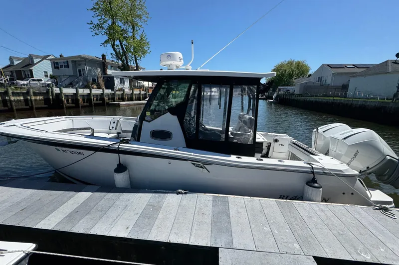 Slide: The Image of 2020 Blackfin 272 CC boat docked in a marina, featuring dual Mercury outboard engines. - 34