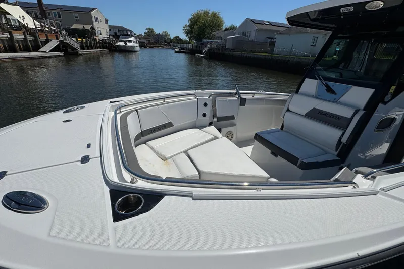 Slide: The Image of 2020 Blackfin 272 CC boat with spacious seating, docked in a serene waterfront setting. - 35