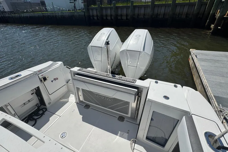 Slide: The Image of 2020 Blackfin 272 CC boat with dual outboard engines docked by the water. - 4
