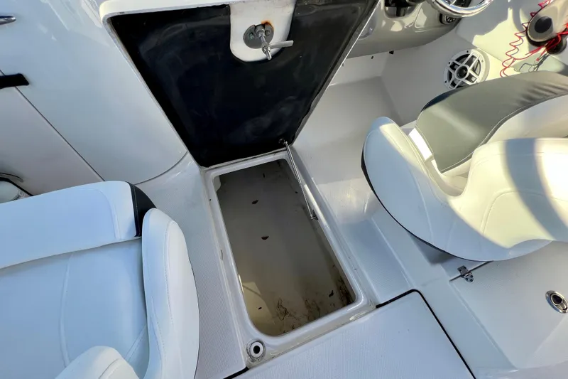 Slide: The Image of 2024 Robalo R207 Dual Console boat interior with open storage compartment and seating. - 12