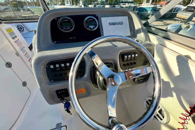 Slide: The Image of 2024 Robalo R207 Dual Console boat dashboard with steering wheel and control panel. - 13