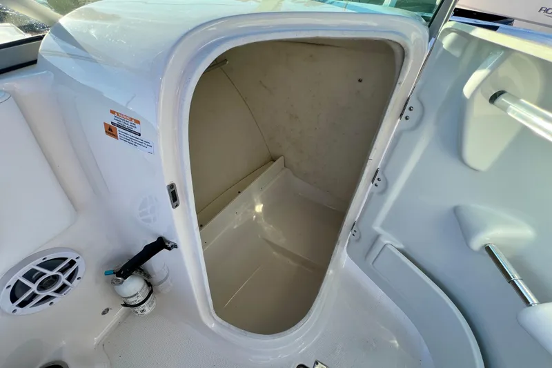 Slide: The Image of 2024 Robalo R207 Dual Console storage compartment with open hatch and visible interior. - 18