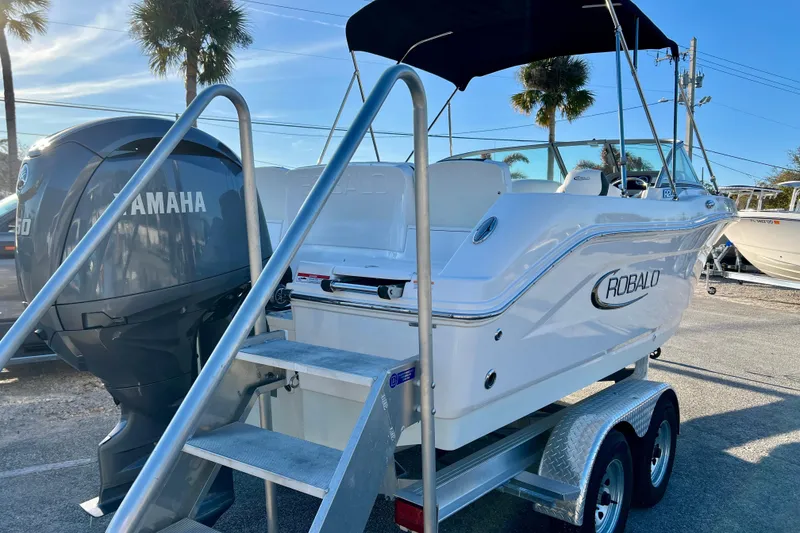 Slide: The Image of 2024 Robalo R207 Dual Console boat with Yamaha engine on trailer, under sunny skies. - 7