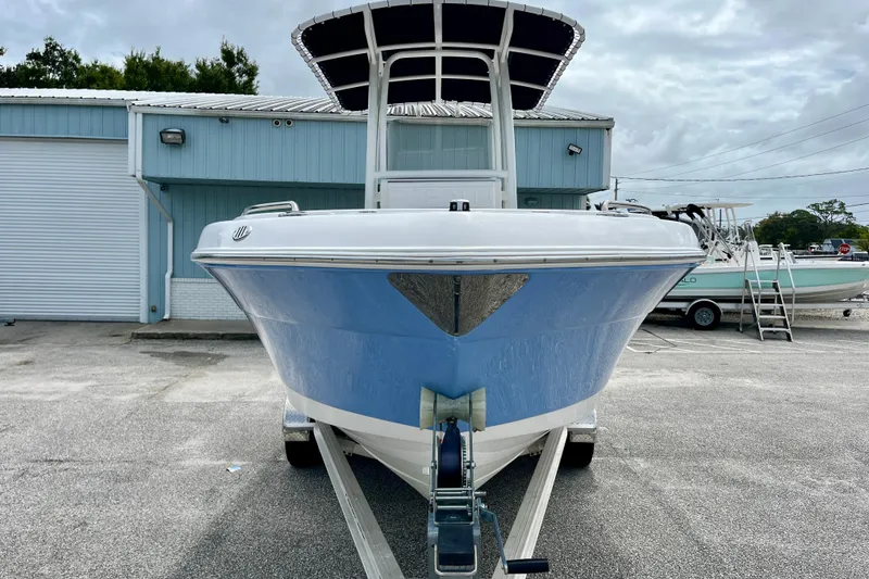 Slide: The Image of 2024 Robalo R222 Center Console boat on trailer, parked outside a blue building. - 3