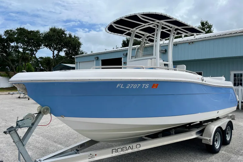 Slide: The Image of 2024 Robalo R222 Center Console boat on trailer, blue hull, parked outdoors. - 4