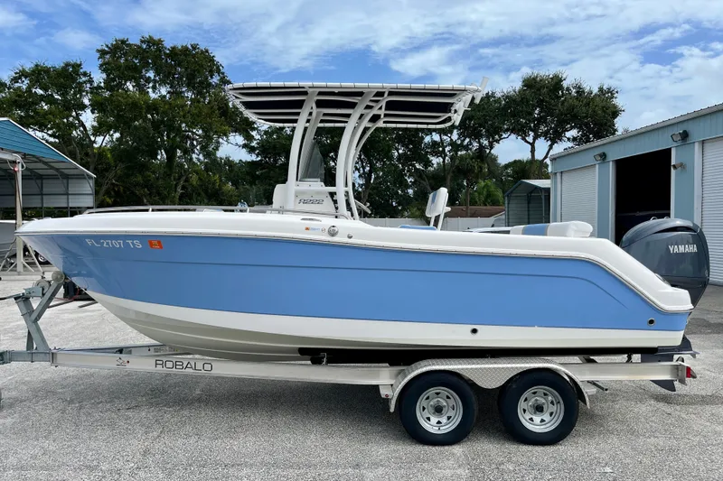 Slide: The Image of 2024 Robalo R222 Center Console boat on trailer, blue and white design. - 5
