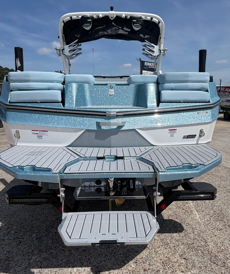 Slide: The Image of Rear view of 2026 MasterCraft XT24 boat with sparkling blue finish. - 10