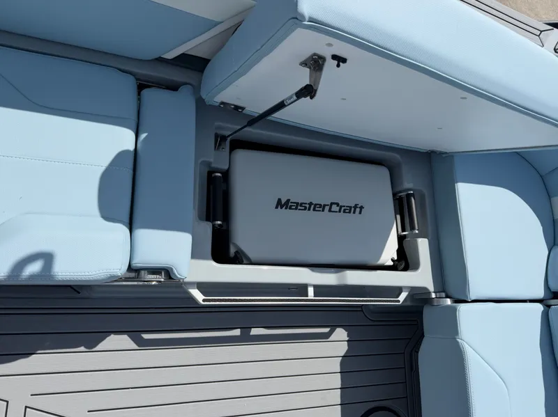 Slide: The Image of MasterCraft XT24 2026 boat with storage compartment and blue seating. - 21