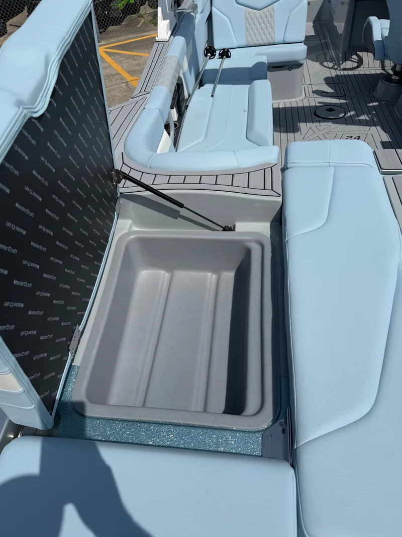 Slide: The Image of Interior of 2026 MasterCraft XT24 with storage compartment and blue seating. - 23