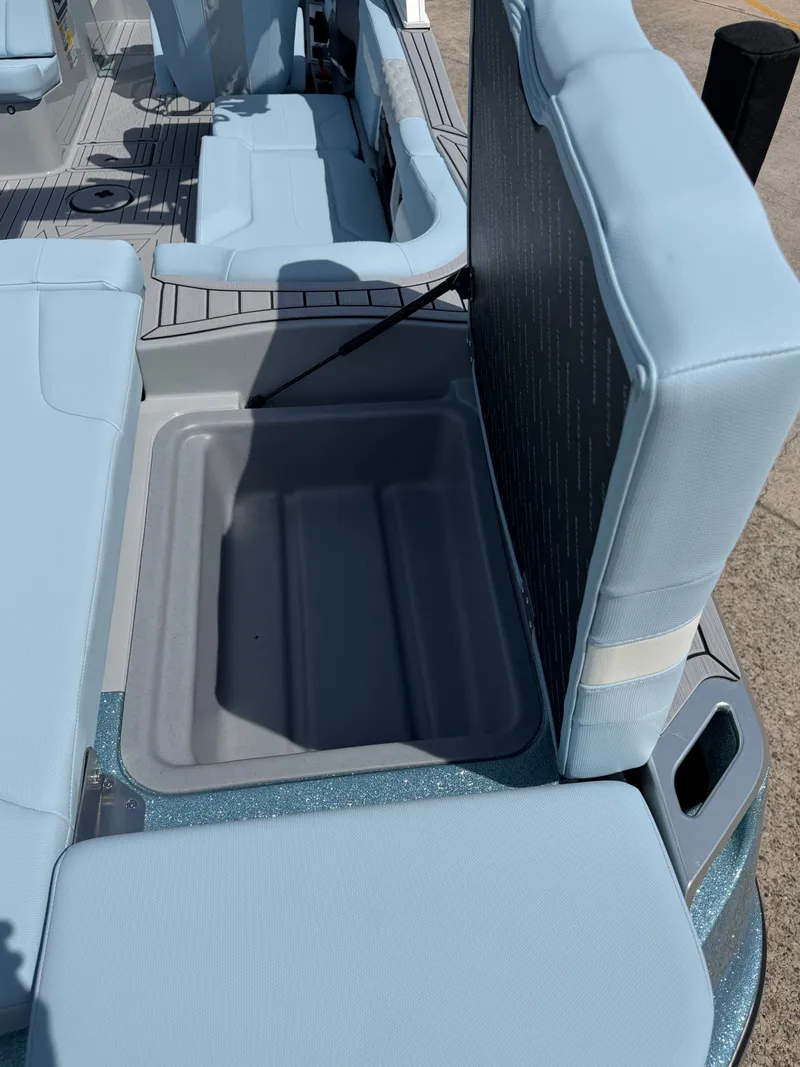 Slide: The Image of MasterCraft XT24 2026 boat with open storage compartment and blue seating. - 25