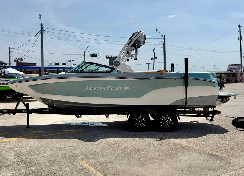 Slide: The Image of 2026 MasterCraft XT24 boat parked outdoors on a trailer. - 3