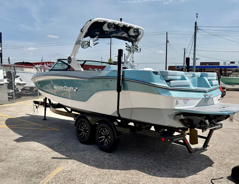 Slide: The Image of 2026 MasterCraft XT24 boat parked on trailer outdoors. - 7
