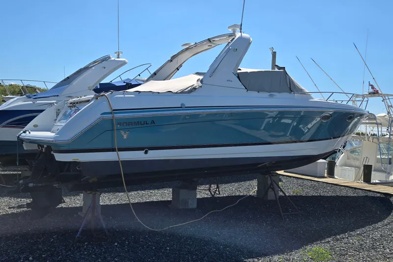 The Image of 2005 Formula 330 Sun Sport boat on dry dock, blue and white exterior. - 0