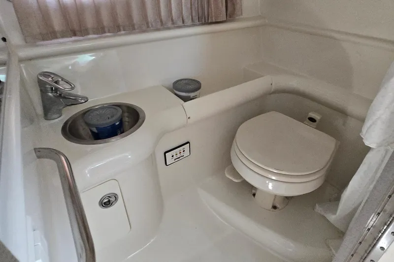 Slide: The Image of Compact bathroom in a 2005 Formula 330 Sun Sport boat, featuring a toilet and sink. - 11