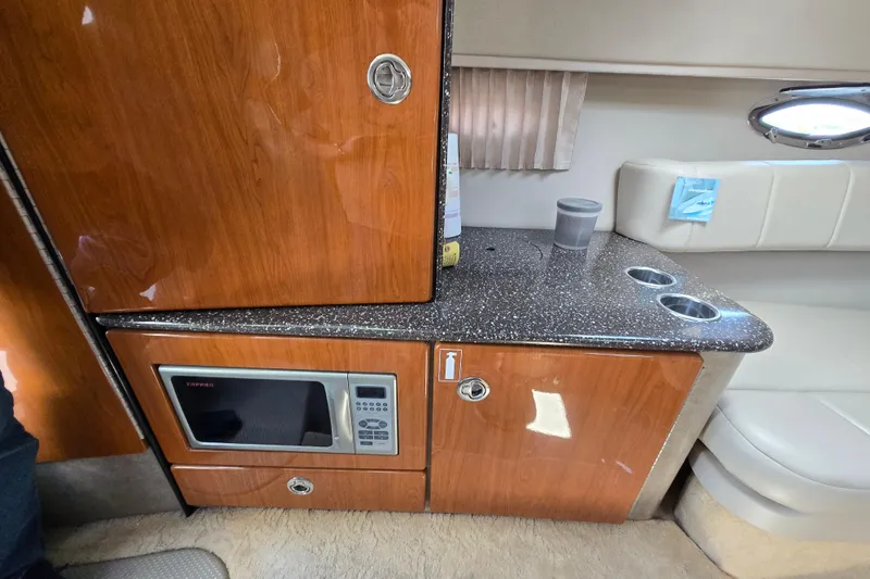 Slide: The Image of Interior of a 2005 Formula 330 Sun Sport boat featuring a microwave and wooden cabinetry. - 13