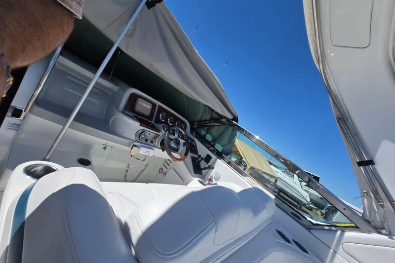 Slide: The Image of 2005 Formula 330 Sun Sport boat interior with steering wheel and dashboard under canopy. - 18