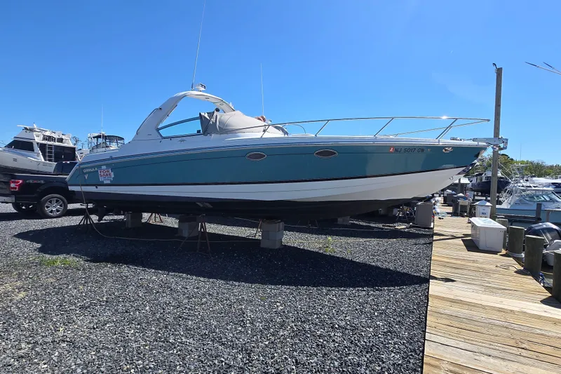Slide: The Image of 2005 Formula 330 Sun Sport boat on display at a marina, clear blue sky. - 21