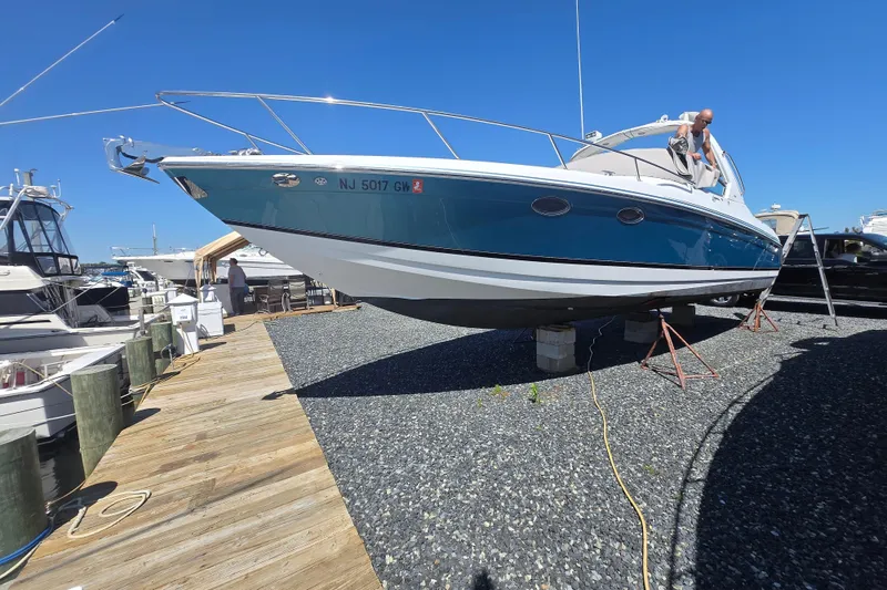 Slide: The Image of 2005 Formula 330 Sun Sport boat on dry dock, blue hull, sunny day. - 6