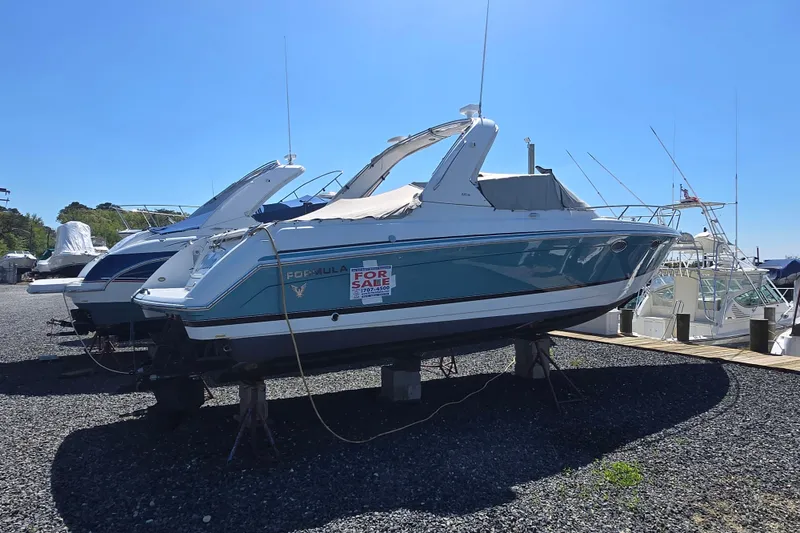 Slide: The Image of 2005 Formula 330 Sun Sport boat for sale, docked on gravel, clear sky background. - 7