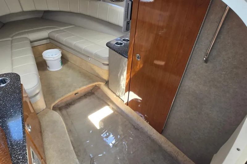 Slide: The Image of Interior of a 2005 Formula 330 Sun Sport boat with beige seating and wooden cabinetry. - 8