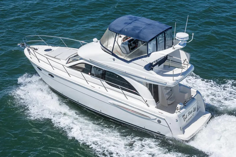 Slide: The Image of 2003 Meridian 341 Sedan cruising on open water, featuring sleek design and spacious deck. - 2