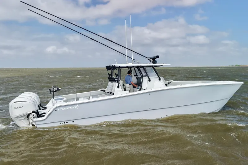 Slide: The Image of 2024 Freeman 38 boat cruising on choppy waters with Yamaha engines. - 1